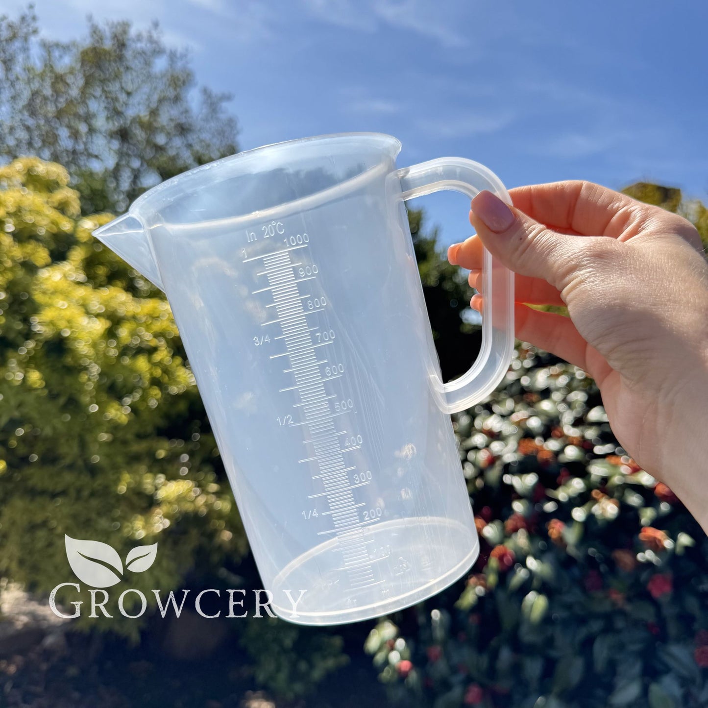 1L measuring jug held outdoors – clear BPA-free plastic with accurate printed scale for liquids