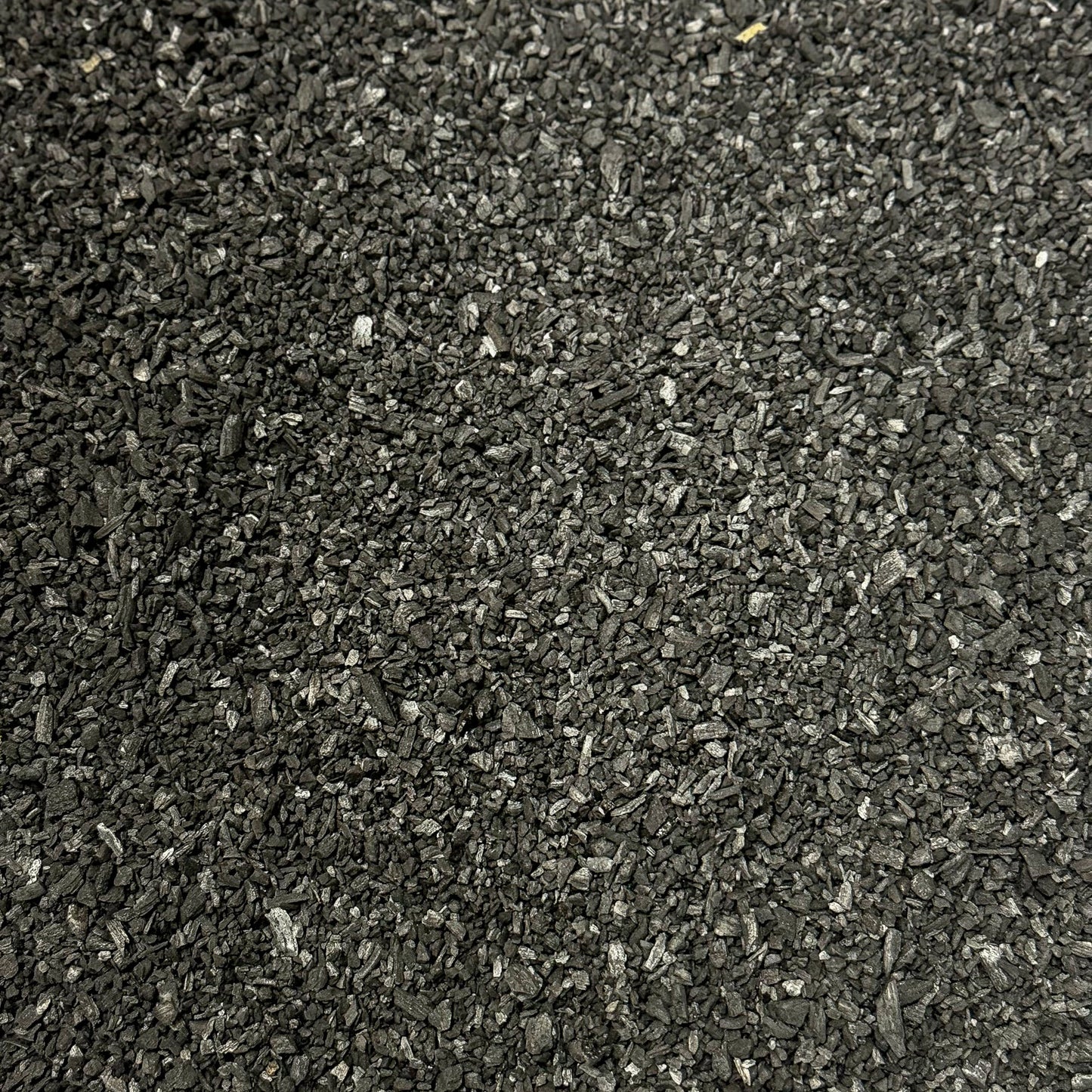 Pure Growcery Activated Biochar in a pile, showing its granular texture for carbon sequestration and toxin reduction in soil.