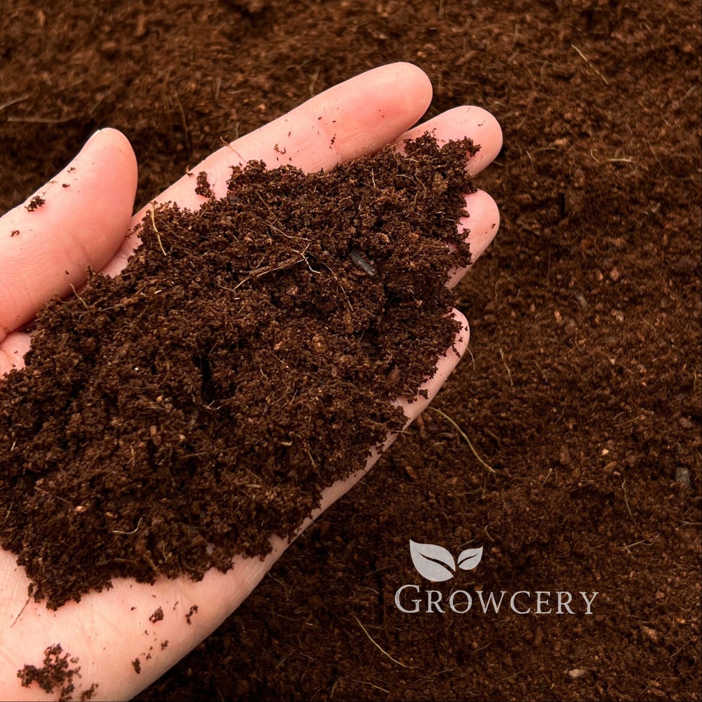 Handful of coco coir soil amendment, perfect for gardening and hydroponics, Growcery branding visible