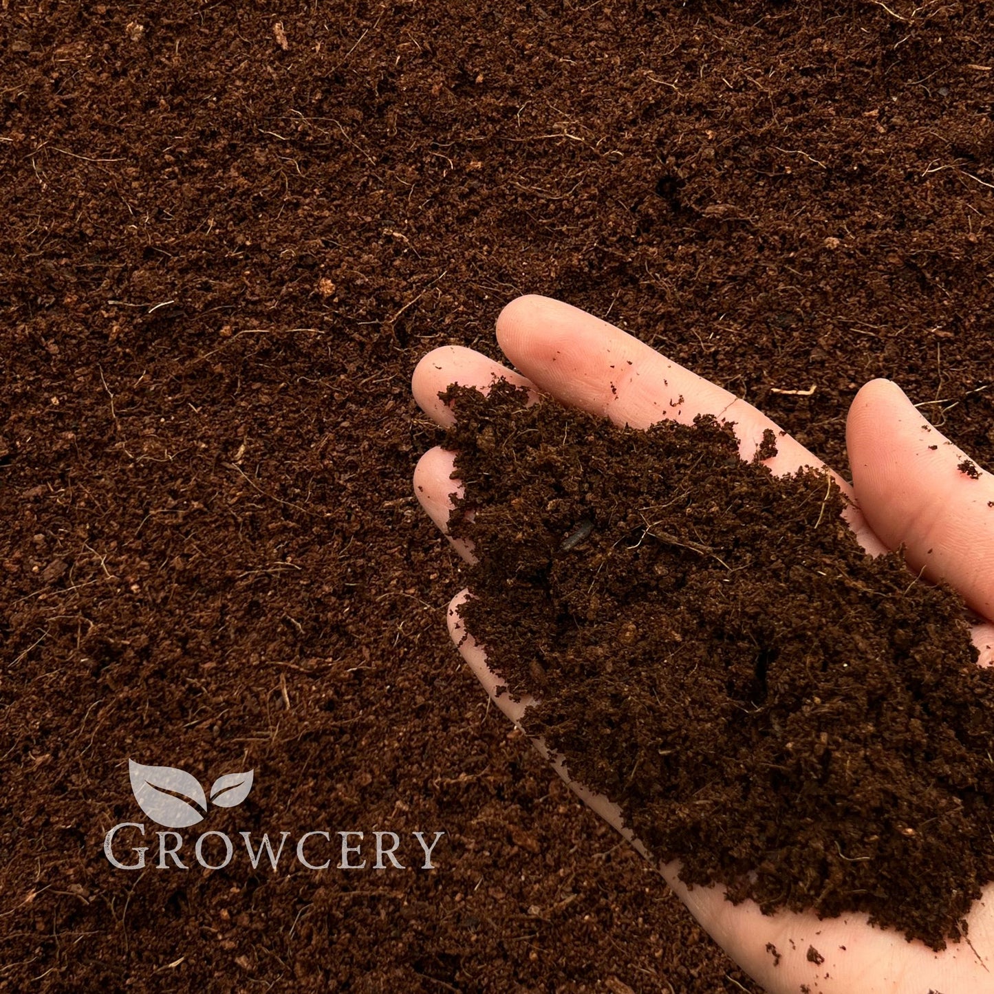 Handful of washed and buffered coco coir soil amendment, perfect for gardening and hydroponics, Growcery branding visible