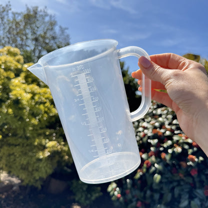1L measuring jug held outdoors – clear BPA-free plastic with accurate printed scale for liquids