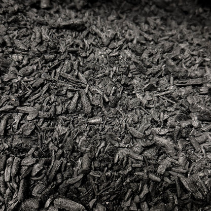 Close-up macro photo of activated biochar pieces showing the texture and size of the soil additive.